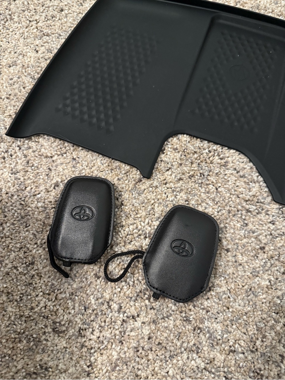 Two Toyota grand Highlander key gloves and rubber mat for phone charging insert.